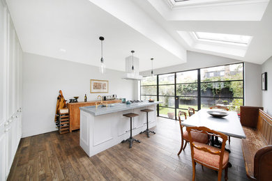 Mittelgroße Stilmix Wohnküche mit Unterbauwaschbecken, Kassettenfronten, grauen Schränken, Zink-Arbeitsplatte, braunem Holzboden, Kücheninsel und braunem Boden in London