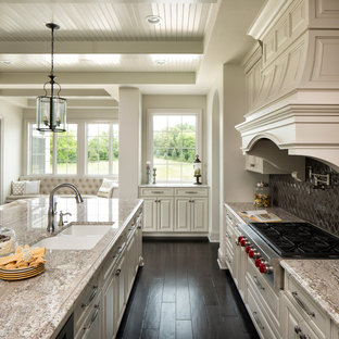 Foto de cocina clásica con fregadero bajoencimera, armarios con paneles empotrados, puertas de armario blancas, salpicadero metalizado, salpicadero de metal, electrodomésticos de acero inoxidable, suelo de madera oscura y una isla