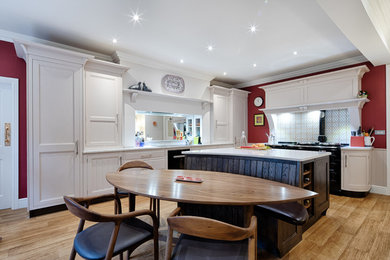 Inspiration for a medium sized traditional u-shaped kitchen in Other with beaded cabinets, quartz worktops, mirror splashback, black appliances and an island.