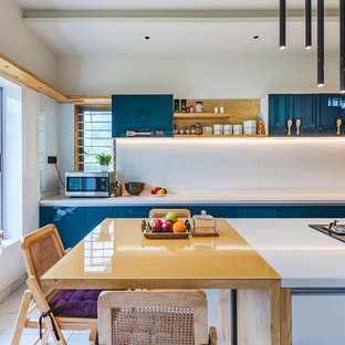 Photo of an asian galley eat-in kitchen in Ahmedabad with flat-panel cabinets, blue cabinets, white splashback, glass sheet splashback, white floor and yellow benchtop.