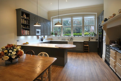 This is an example of a traditional open plan kitchen in Other with a belfast sink and an island.