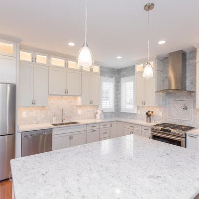 Inspiration for a mid-sized timeless l-shaped medium tone wood floor and brown floor eat-in kitchen remodel in DC Metro with an undermount sink, recessed-panel cabinets, white cabinets, marble countertops, gray backsplash, marble backsplash, stainless steel appliances and an island