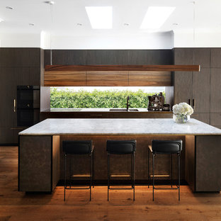 Inspiration for a contemporary l-shaped kitchen in Melbourne with an integrated sink, flat-panel cabinets, dark wood cabinets, window splashback, panelled appliances, medium hardwood floors, with island, brown floor and grey benchtop.