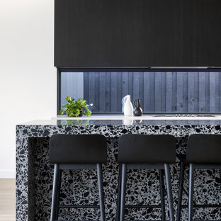 Contemporary kitchen in Melbourne with flat-panel cabinets, black cabinets, window splashback, light hardwood floors, with island, beige floor and multi-coloured benchtop.
