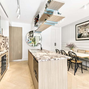 Inspiration for a small contemporary galley open plan kitchen in Sydney with an undermount sink, light wood cabinets, marble benchtops, multi-coloured splashback, marble splashback, black appliances, light hardwood floors, with island, beige floor, flat-panel cabinets and multi-coloured benchtop.