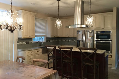 Example of a mid-sized classic l-shaped linoleum floor eat-in kitchen design in Philadelphia with a farmhouse sink, raised-panel cabinets, white cabinets, granite countertops, green backsplash, glass tile backsplash, stainless steel appliances and an island