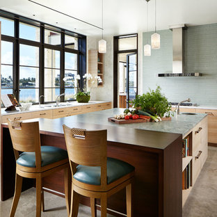 Esempio di una grande cucina etnica con lavello sottopiano, ante lisce, ante in legno chiaro, elettrodomestici in acciaio inossidabile, pavimento in cemento, top in granito, paraspruzzi blu, paraspruzzi con piastrelle diamantate e pavimento marrone