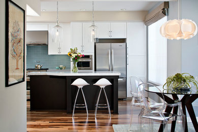 Eat-in kitchen - mid-sized contemporary galley light wood floor eat-in kitchen idea in San Diego with an undermount sink, shaker cabinets, white cabinets, quartz countertops, blue backsplash, subway tile backsplash, stainless steel appliances and an island