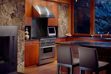デンバーにある広いモダンスタイルのおしゃれなキッチン (アンダーカウンターシンク、フラットパネル扉のキャビネット、中間色木目調キャビネット、シルバーの調理設備、無垢フローリング、グレーのキッチンパネル) の写真