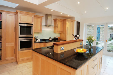 Medium sized contemporary single-wall enclosed kitchen in London with an island and beige floors.