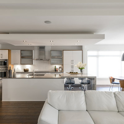 Inspiration for a contemporary galley eat-in kitchen remodel in Ottawa with flat-panel cabinets, white cabinets, white backsplash, stainless steel appliances and glass sheet backsplash