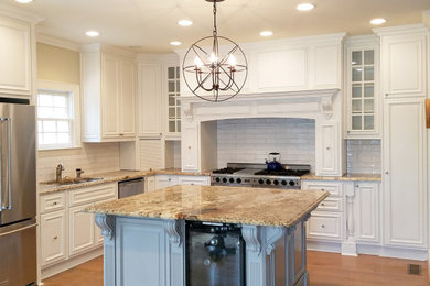 Photo of a large kitchen in Atlanta with raised-panel cabinets, white cabinets, granite worktops, white splashback, ceramic splashback and brown worktops.
