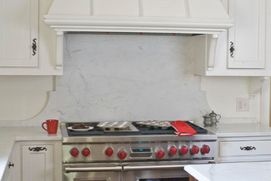 Imagen de cocina comedor tradicional con fregadero sobremueble, puertas de armario blancas, encimera de mármol, salpicadero blanco y electrodomésticos de acero inoxidable