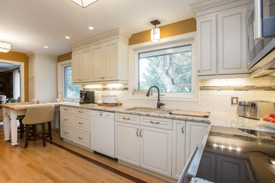 Example of a mid-sized classic u-shaped light wood floor and beige floor eat-in kitchen design in Toronto with an undermount sink, beaded inset cabinets, white cabinets, granite countertops, white backsplash, subway tile backsplash, stainless steel appliances, no island and multicolored countertops