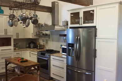 Immagine di una piccola cucina chic chiusa con ante in stile shaker, ante bianche, top in granito, elettrodomestici in acciaio inossidabile, parquet scuro e pavimento marrone