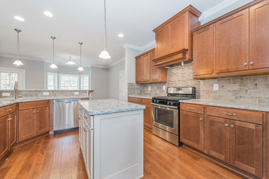 Example of a large classic u-shaped medium tone wood floor open concept kitchen design in New York with an undermount sink, shaker cabinets, medium tone wood cabinets, granite countertops, beige backsplash, ceramic backsplash, stainless steel appliances and an island