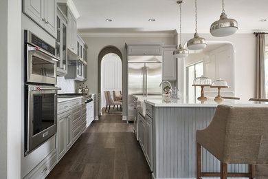 Example of a large transitional u-shaped dark wood floor eat-in kitchen design in Orlando with a farmhouse sink, raised-panel cabinets, gray cabinets, quartz countertops, gray backsplash, ceramic backsplash, stainless steel appliances and an island