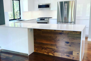 Example of a small minimalist u-shaped dark wood floor and brown floor eat-in kitchen design in Austin with an undermount sink, flat-panel cabinets, white cabinets, quartz countertops, white backsplash, stone slab backsplash, stainless steel appliances, no island and white countertops