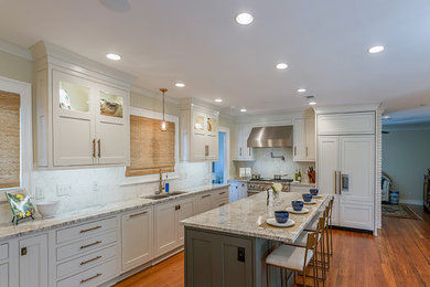 Inspiration for a transitional medium tone wood floor and brown floor eat-in kitchen remodel in Other with an undermount sink, recessed-panel cabinets, white cabinets, granite countertops, white backsplash, stainless steel appliances, an island and beige countertops