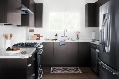 Foto de cocina minimalista con fregadero bajoencimera, salpicadero blanco, salpicadero de azulejos de porcelana, electrodomésticos de acero inoxidable y una isla