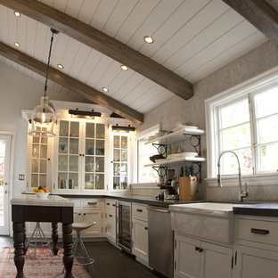This is an example of a country kitchen in Los Angeles with glass-front cabinets, stainless steel appliances, a farmhouse sink and white cabinets.