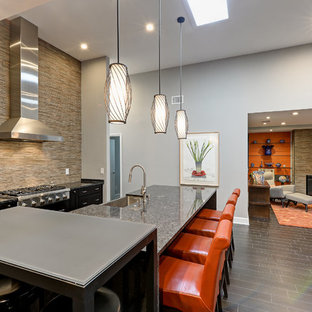Large contemporary galley open plan kitchen in Jacksonville with a farmhouse sink, shaker cabinets, black cabinets, brown splashback, stainless steel appliances, dark hardwood floors, with island, granite benchtops, slate splashback and brown floor.