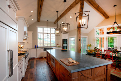 Photo of a rustic u-shaped kitchen/diner in Baltimore with a belfast sink, white cabinets and integrated appliances.