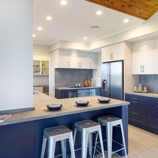 This is an example of a mid-sized country u-shaped separate kitchen in Hamilton with a double-bowl sink, shaker cabinets, blue cabinets, concrete benchtops, grey splashback, stainless steel appliances, ceramic floors, a peninsula, grey floor and grey benchtop.