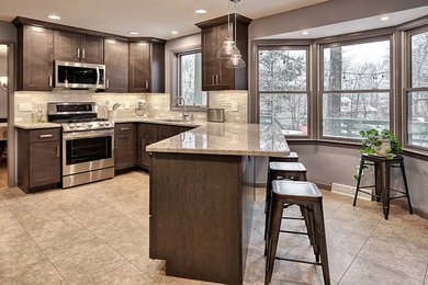 Cette image montre une cuisine de taille moyenne avec un évier encastré, un plan de travail en granite, une crédence en carreau de verre et un électroménager en acier inoxydable.