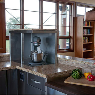 Large contemporary u-shaped eat-in kitchen in Boston with stainless steel cabinets, glass tile splashback, stainless steel appliances, multiple islands, brown splashback, recycled glass benchtops, flat-panel cabinets and multi-coloured benchtop.