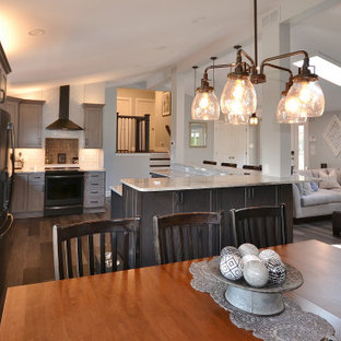 Large transitional eat-in kitchen in Philadelphia with an undermount sink, recessed-panel cabinets, grey cabinets, granite benchtops, white splashback, subway tile splashback, stainless steel appliances, vinyl floors, with island, brown floor and white benchtop.