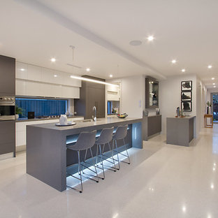 Contemporary galley kitchen in Gold Coast - Tweed with an undermount sink, flat-panel cabinets, grey cabinets, stainless steel appliances, with island, grey floor and grey benchtop.