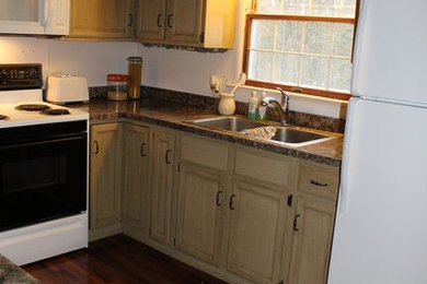 ワシントンD.C.にある低価格のカントリー風のおしゃれなキッチン (ダブルシンク、レイズドパネル扉のキャビネット、ヴィンテージ仕上げキャビネット、ラミネートカウンター) の写真