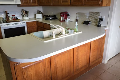 Small elegant u-shaped eat-in kitchen photo in Other with an undermount sink, quartz countertops, beige backsplash, glass tile backsplash and white appliances