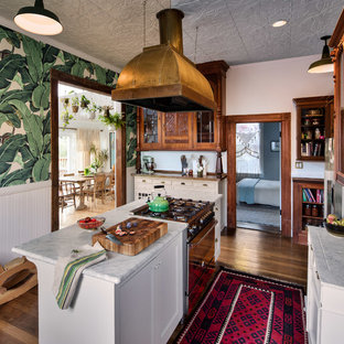 This is an example of a victorian separate kitchen in San Francisco with shaker cabinets, white cabinets and dark hardwood floors.