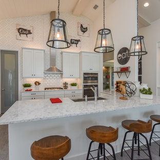 Country u-shaped kitchen in Milwaukee with a farmhouse sink, shaker cabinets, white cabinets, white splashback, subway tile splashback, stainless steel appliances, dark hardwood floors, a peninsula and grey floor.