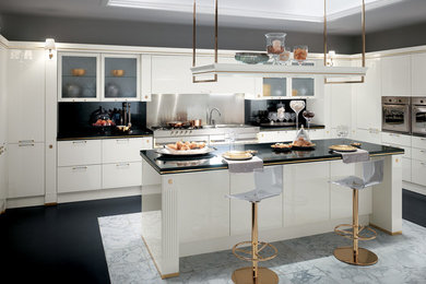 Example of a large trendy u-shaped marble floor and multicolored floor enclosed kitchen design in New York with an undermount sink, flat-panel cabinets, white cabinets, granite countertops, black backsplash, stone slab backsplash, stainless steel appliances and an island
