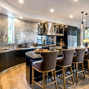 This is an example of a contemporary kitchen in Adelaide with flat-panel cabinets, black cabinets, stainless steel benchtops, stainless steel appliances, with island, an integrated sink, metallic splashback, metal splashback, light hardwood floors and beige floor.