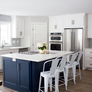 Large transitional eat-in kitchen appliance - Large transitional l-shaped vinyl floor and brown floor eat-in kitchen photo in Other with an undermount sink, white cabinets, quartz countertops, gray backsplash, porcelain backsplash, stainless steel appliances, an island, white countertops and shaker cabinets