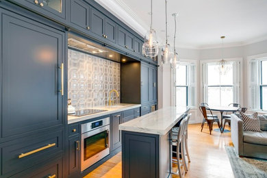 Inspiration for a transitional medium tone wood floor open concept kitchen remodel in Boston with an undermount sink, beaded inset cabinets, blue cabinets, white backsplash, stainless steel appliances, an island and white countertops