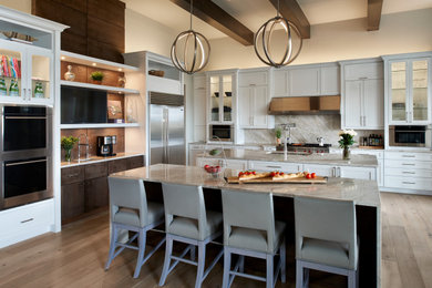 Inspiration for a large transitional u-shaped medium tone wood floor, brown floor and exposed beam open concept kitchen remodel in Denver with an undermount sink, shaker cabinets, white cabinets, gray backsplash, two islands and gray countertops
