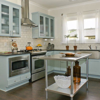 Example of a mid-sized cottage l-shaped dark wood floor eat-in kitchen design in Birmingham with stainless steel appliances, a farmhouse sink, shaker cabinets, blue cabinets, solid surface countertops, white backsplash, subway tile backsplash and an island