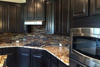 Example of a mid-sized classic galley terra-cotta tile enclosed kitchen design in Dallas with an undermount sink, raised-panel cabinets, dark wood cabinets, granite countertops, multicolored backsplash, stone slab backsplash, stainless steel appliances and an island