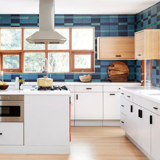 Ispirazione per una grande cucina ad U moderna con ante lisce, ante bianche, paraspruzzi multicolore, paraspruzzi con piastrelle in ceramica, elettrodomestici colorati, parquet chiaro, isola, pavimento beige, top bianco e lavello sottopiano