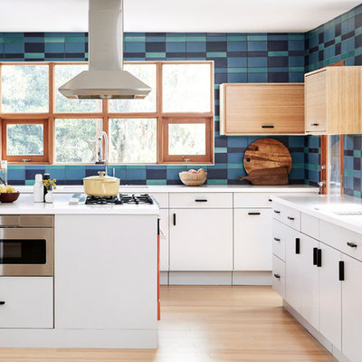 Kitchen - large 1960s u-shaped light wood floor and beige floor kitchen idea in Los Angeles with flat-panel cabinets, white cabinets, multicolored backsplash, ceramic backsplash, colored appliances, an island, white countertops and an undermount sink