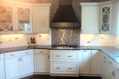 Immagine di una cucina moderna chiusa e di medie dimensioni con ante con bugna sagomata, ante bianche, top in granito, paraspruzzi beige, paraspruzzi con piastrelle di cemento e elettrodomestici in acciaio inossidabile