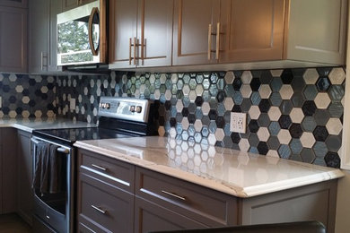 Example of a mid-sized u-shaped vinyl floor and gray floor eat-in kitchen design in Edmonton with a farmhouse sink, shaker cabinets, gray cabinets, quartzite countertops, multicolored backsplash, glass tile backsplash, stainless steel appliances, an island and white countertops