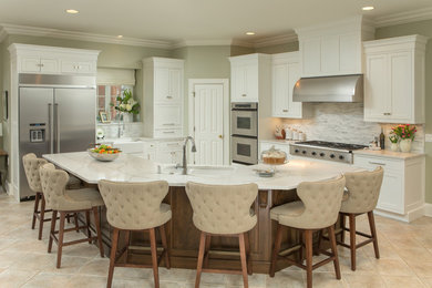 Example of a large transitional l-shaped porcelain tile and beige floor kitchen design in Atlanta with a double-bowl sink, shaker cabinets, white cabinets, marble countertops, white backsplash, stainless steel appliances and an island