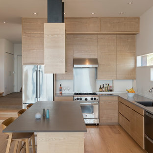 This is an example of a mid-sized contemporary l-shaped open plan kitchen in Seattle with an undermount sink, flat-panel cabinets, light wood cabinets, quartz benchtops, grey splashback, slate splashback, stainless steel appliances, with island, brown floor and medium hardwood floors.