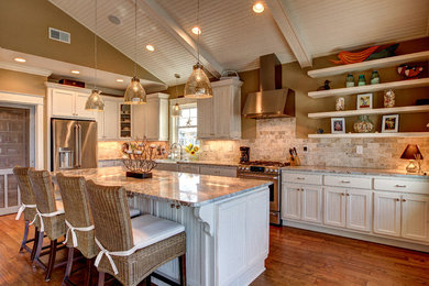 Beach style l-shaped dark wood floor kitchen photo in Other with a farmhouse sink, white cabinets, multicolored backsplash, stainless steel appliances, an island and travertine backsplash